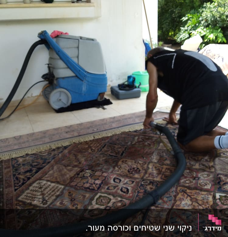 אדם מנקה שטיח עם מכונת ניקוי ושואב אבק